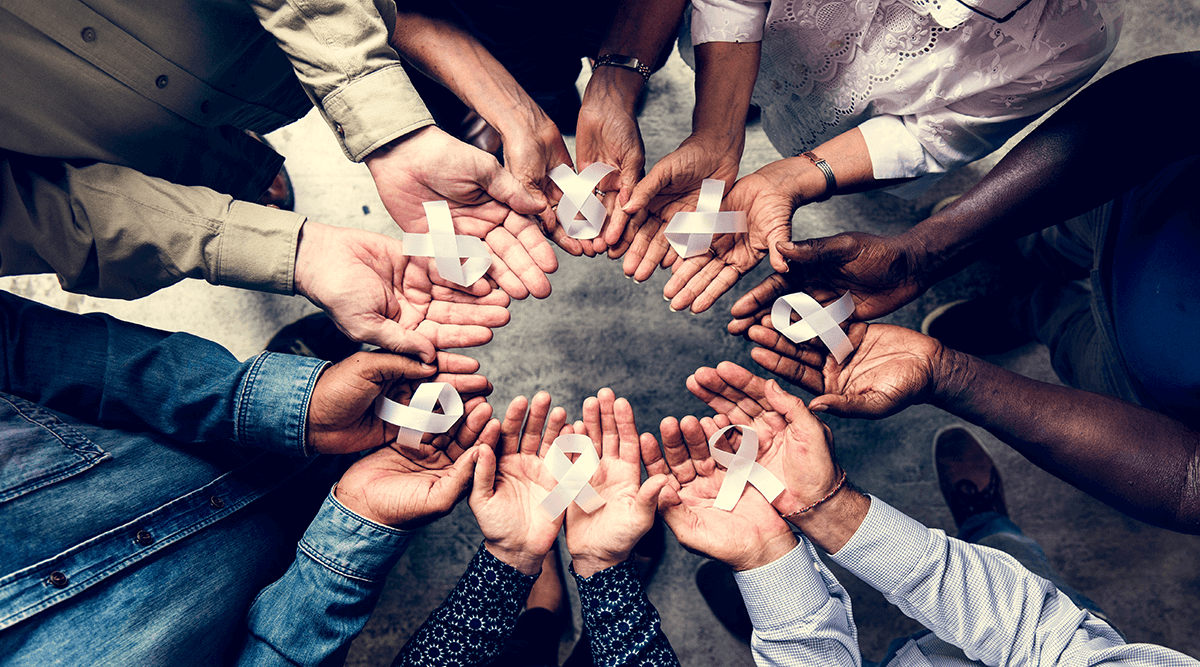 Group of hands holding white ribbons