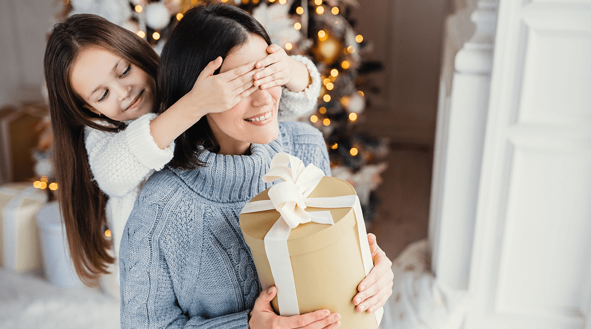 Young girl surprising her mom with a gift
