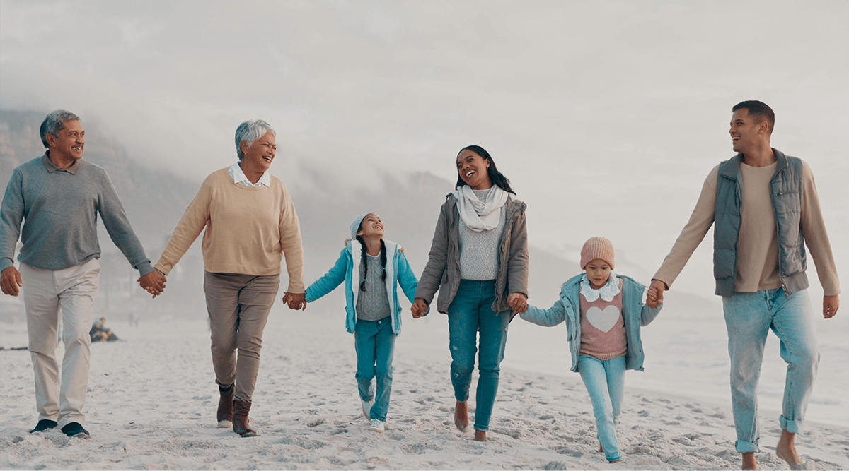 Family holding hands and walking along the beach