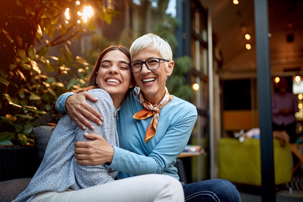 Two women across generations embracing and smiling together, representing women leading family financial planning, multigenerational wealth conversations, and retirement planning decisions in Minnesota.