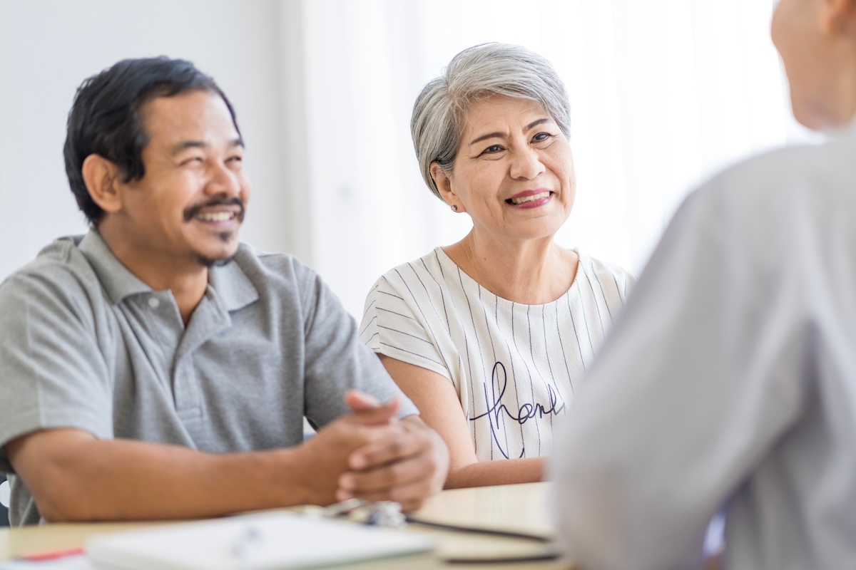 Couple meeting with financial advisor to review investment portfolio and retirement plan, illustrating concept of seeking a second opinion on financial strategy for pre-retirees in Minnesota.