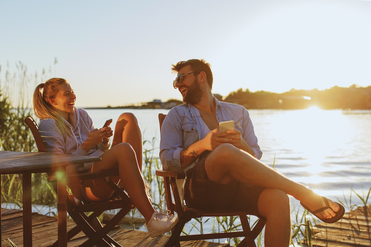 Couple relaxing on a lakeside dock at sunset, illustrating lifestyle planning and financial planning focused on aligning wealth with travel, meaningful experiences, and long-term life goals in Minnesota.