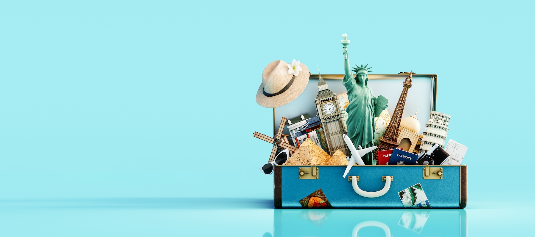 Open suitcase filled with travel landmarks, passports, airplane, and vacation items, representing travel planning, retirement travel goals, and aligning lifestyle aspirations with a comprehensive financial plan in Minnesota.